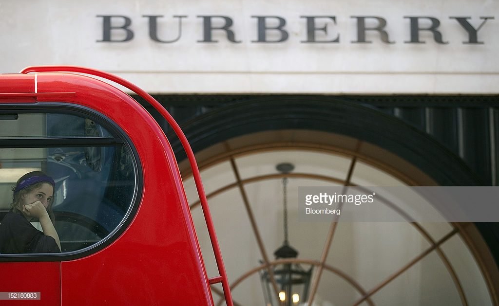 A passenger looks from the window of a double-decker London bus as it passes Burberry Group Plc's new flagship store in London, U.K., on Monday, Sept. 17, 2012. Burberry, the U.K.'s largest luxury house won customers in the first half of the last decade by plastering its camel, red and black check on everything from baseball caps to dog collars. Photographer: Simon Dawson/Bloomberg via Getty Images